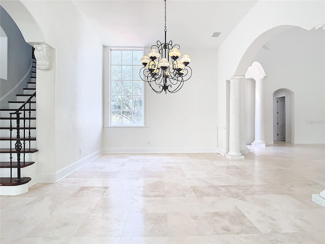 unfurnished dining area featuring ornate columns and an inviting chandelier