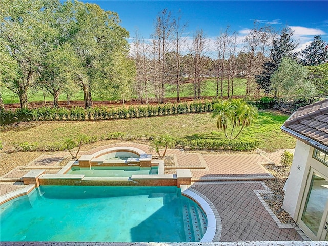 view of pool featuring a yard and an in ground hot tub