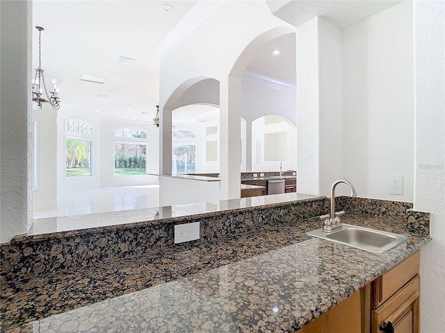 interior space featuring sink, crown molding, stainless steel dishwasher, ceiling fan, and dark stone counters