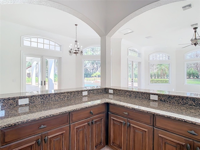 kitchen with decorative light fixtures, french doors, a healthy amount of sunlight, and stone countertops