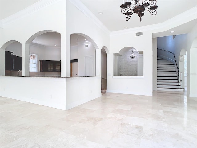 interior space with a notable chandelier, crown molding, and sink