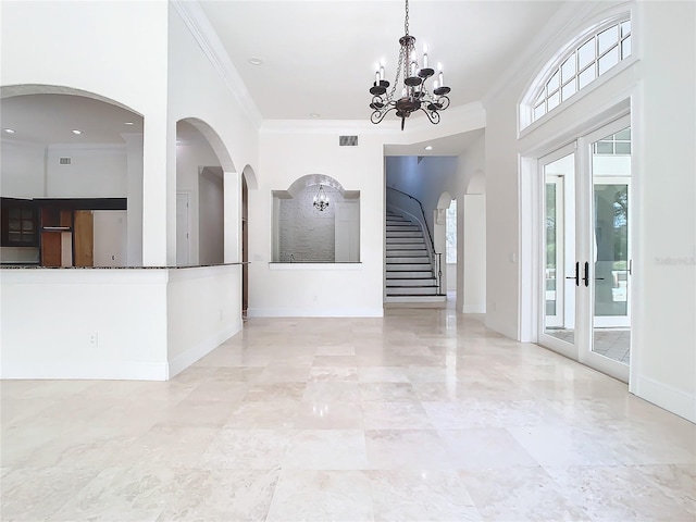 interior space with crown molding, french doors, and a notable chandelier