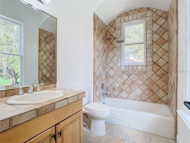 full bathroom with vanity, tiled shower / bath, tile patterned flooring, and toilet