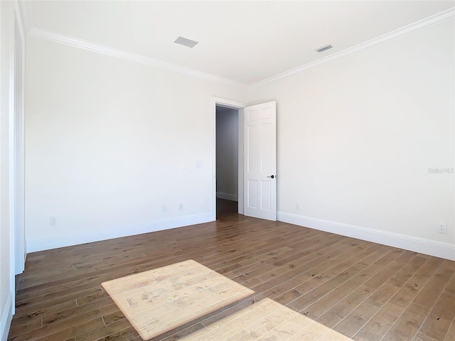 empty room featuring ornamental molding and dark hardwood / wood-style floors