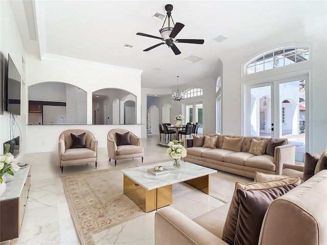 living room featuring crown molding, ceiling fan with notable chandelier, and french doors