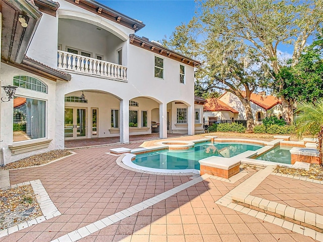 view of pool with an in ground hot tub and a patio