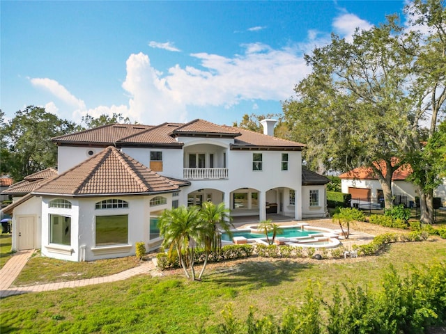 back of property with a patio, a balcony, and a yard