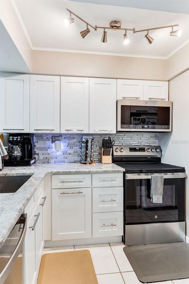 kitchen with appliances with stainless steel finishes, tasteful backsplash, white cabinets, ornamental molding, and light stone countertops