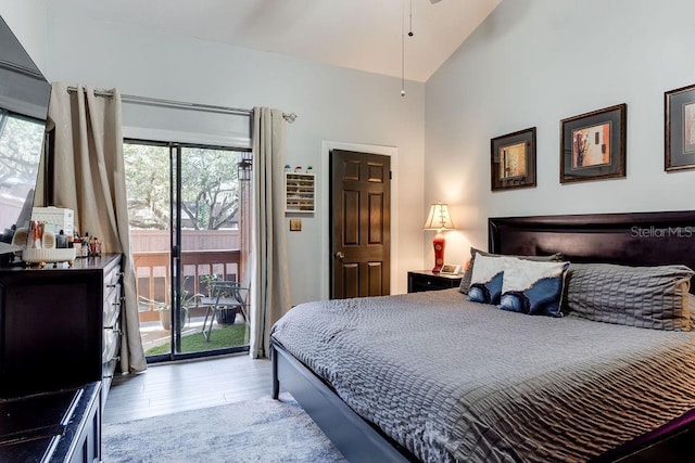 bedroom featuring vaulted ceiling, access to outside, and light wood-type flooring