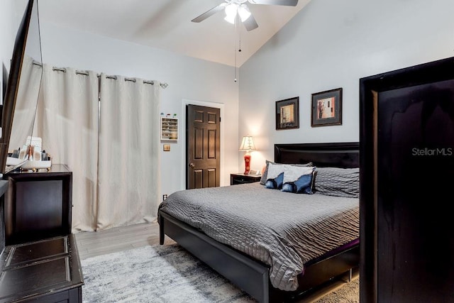 bedroom with ceiling fan, lofted ceiling, and light hardwood / wood-style flooring