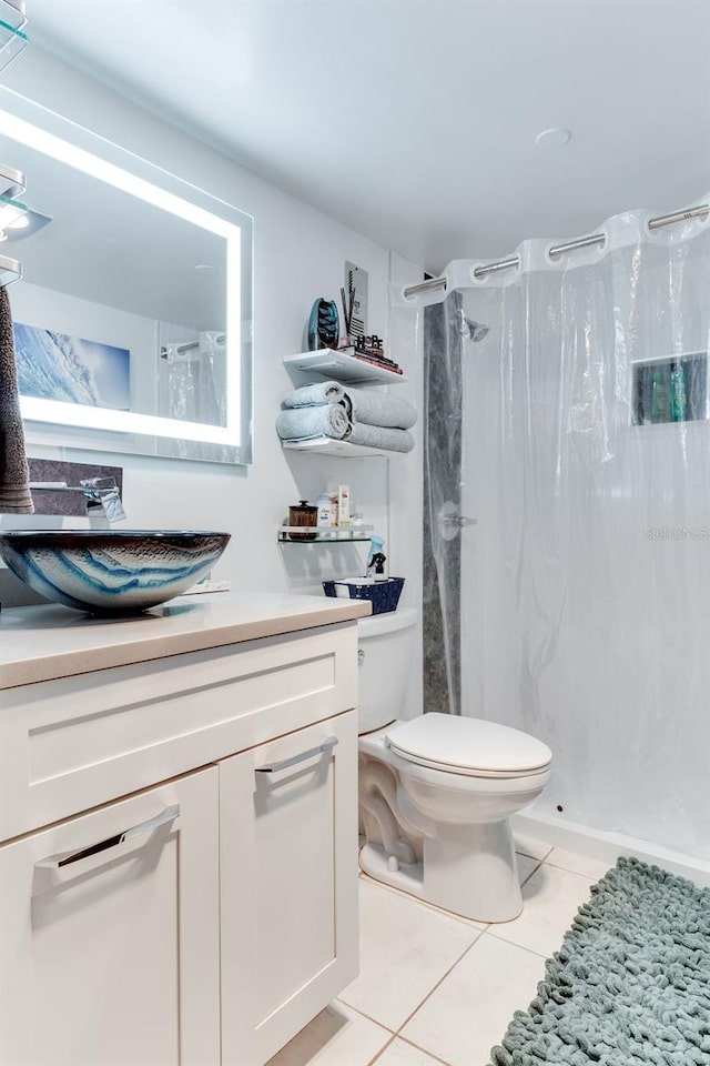 bathroom with a shower with curtain, vanity, toilet, and tile patterned flooring