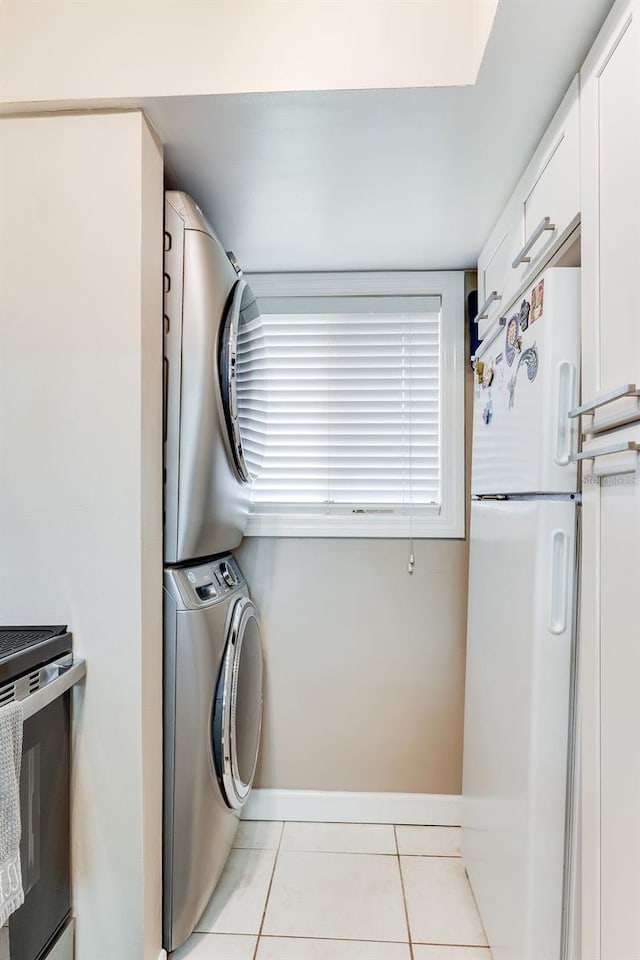 laundry area featuring stacked washer and dryer and light tile patterned floors