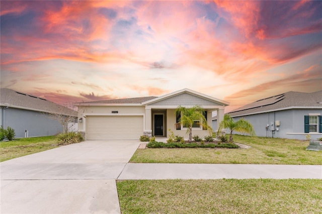 view of front of property with a garage and a yard