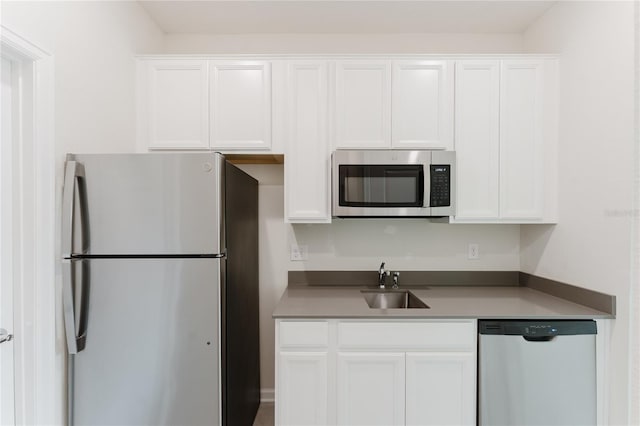 kitchen with stainless steel appliances, sink, and white cabinets