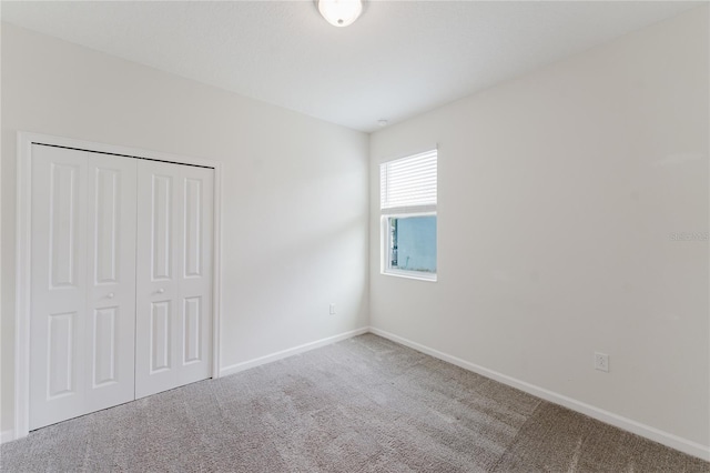 unfurnished bedroom featuring carpet flooring and a closet