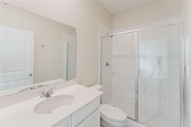 bathroom featuring an enclosed shower, vanity, and toilet