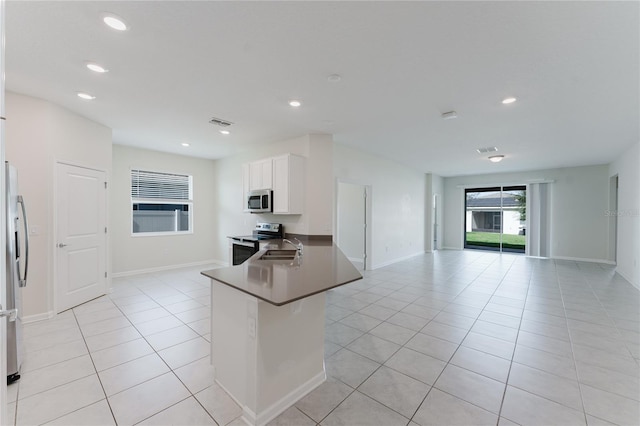 kitchen with white cabinetry, sink, light tile patterned floors, kitchen peninsula, and stainless steel appliances