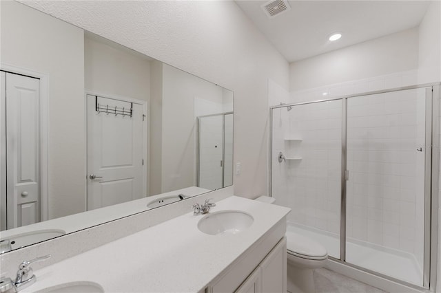 bathroom featuring vanity, toilet, and an enclosed shower