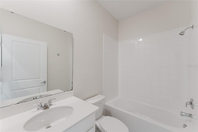 full bathroom with tiled shower / bath, vanity, and toilet