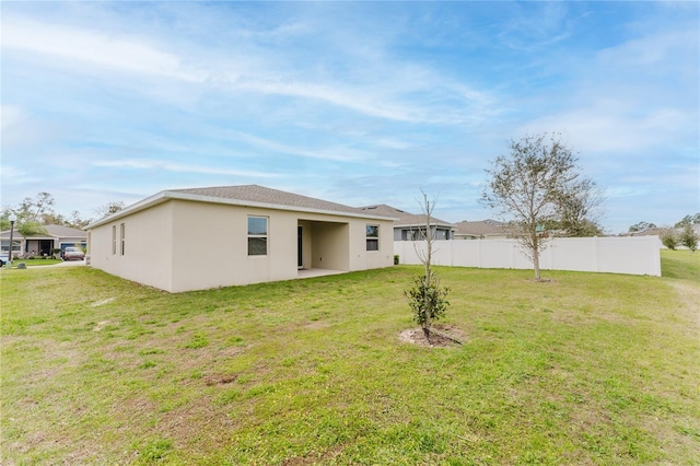 rear view of property featuring a yard