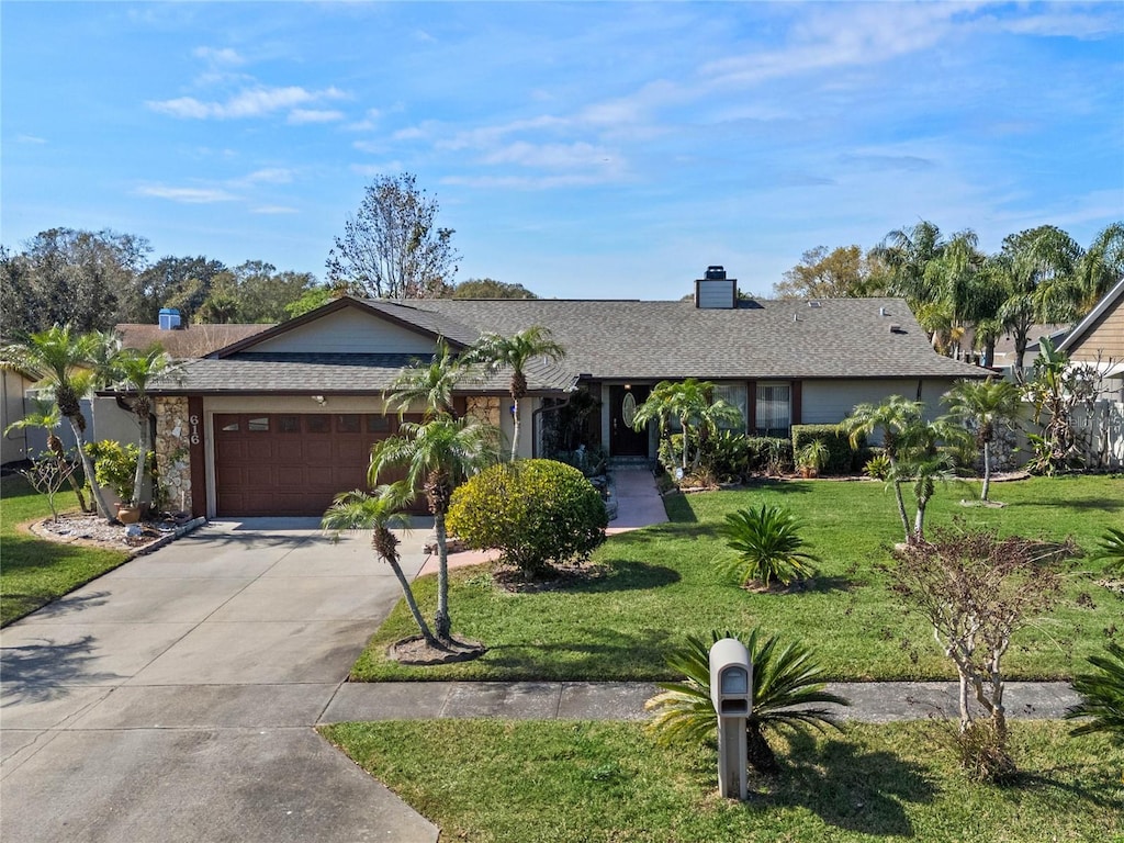 ranch-style house with a garage and a front lawn