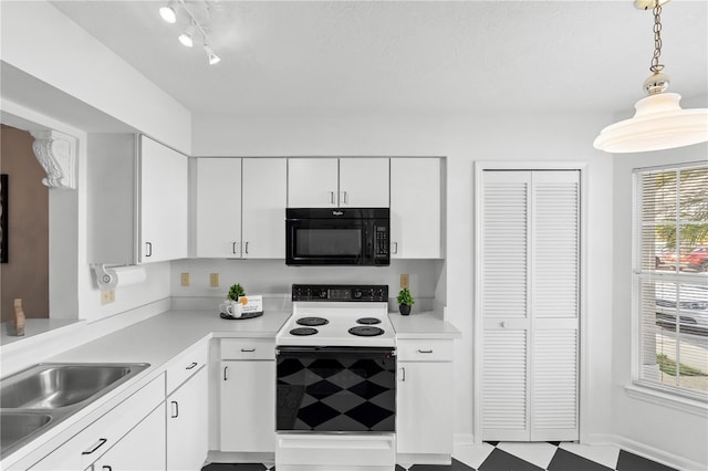 kitchen with pendant lighting, range with electric stovetop, sink, and white cabinets