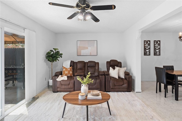 living room with ceiling fan and a textured ceiling