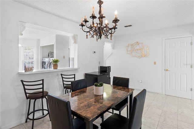 dining space with washer / clothes dryer and a textured ceiling
