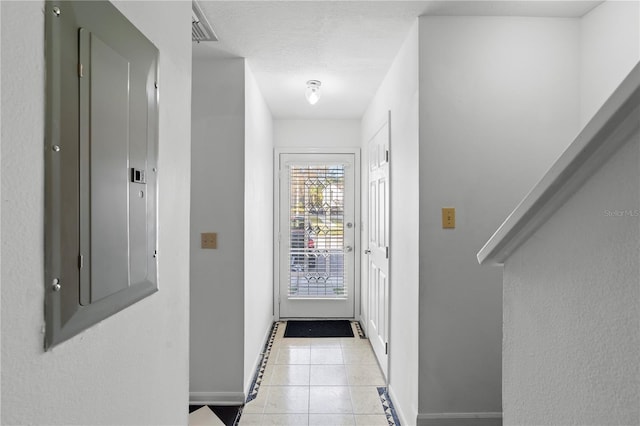 doorway featuring light tile patterned floors, electric panel, and a textured ceiling