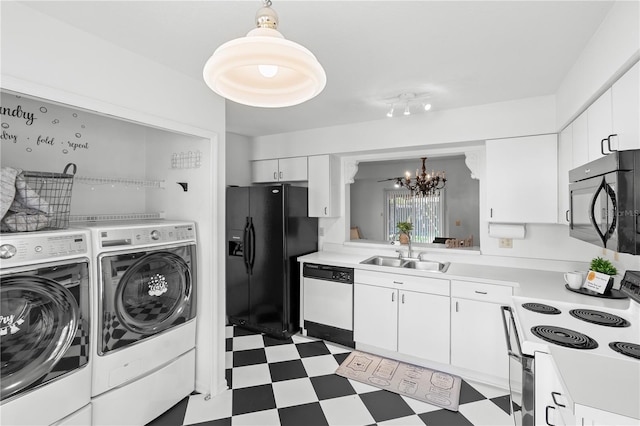 kitchen with sink, white appliances, white cabinetry, an inviting chandelier, and washer and dryer