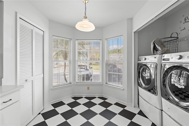 laundry area with separate washer and dryer and a textured ceiling