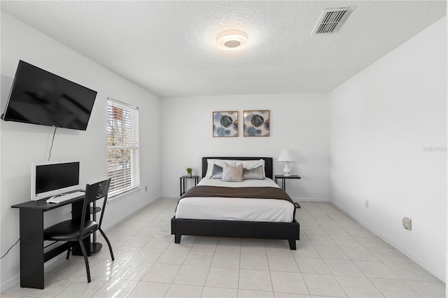 bedroom with a textured ceiling and light tile patterned floors