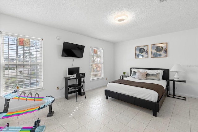 bedroom with light tile patterned flooring and a textured ceiling