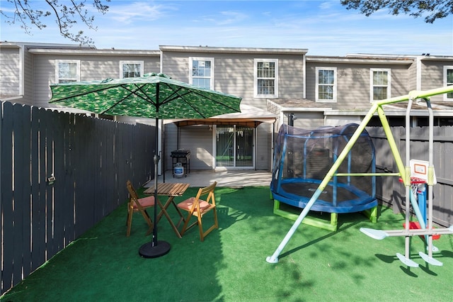 exterior space featuring a gazebo, a trampoline, and a lawn