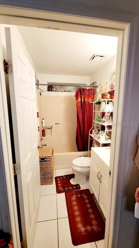 1417 Brookebridge Dr, Orlando, FL 32825 - bathroom with visible vents, toilet, tile patterned flooring, shower / bathtub combination with curtain, and vanity