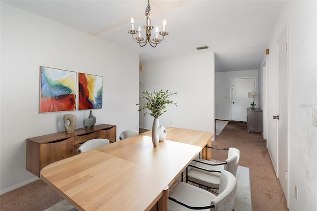 carpeted dining space with an inviting chandelier