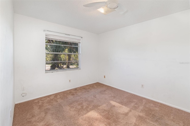 spare room featuring ceiling fan, carpet floors, and a textured ceiling