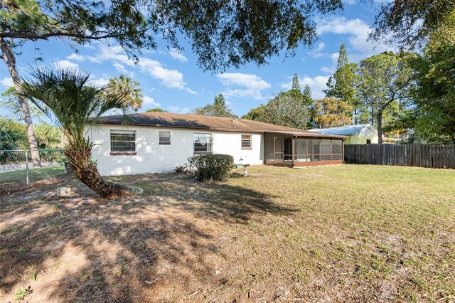 back of house featuring a yard and a sunroom