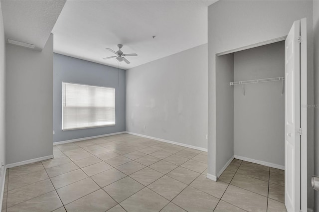 unfurnished bedroom with light tile patterned floors, a closet, and ceiling fan