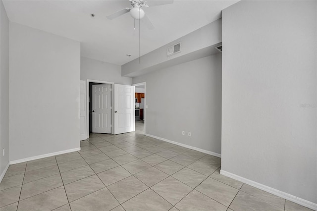 tiled spare room with ceiling fan