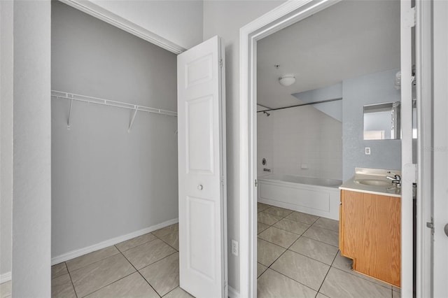 bathroom with vanity, tile patterned flooring, and a washtub