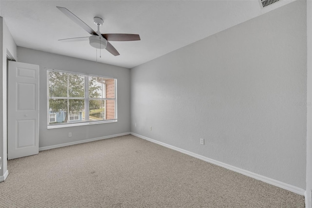 carpeted spare room with ceiling fan