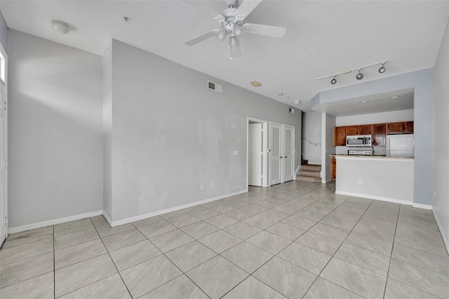 unfurnished living room with light tile patterned floors, rail lighting, and ceiling fan