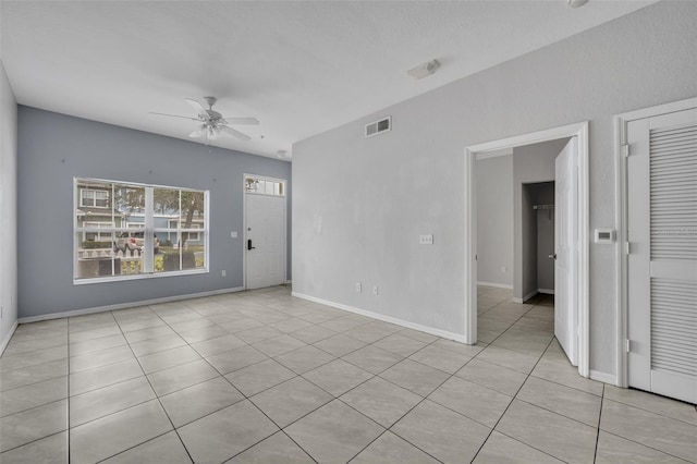 tiled spare room with ceiling fan