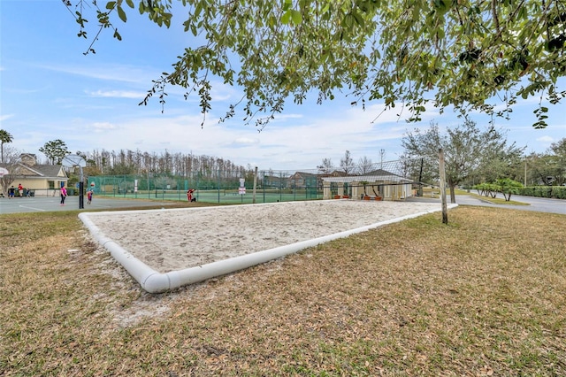 surrounding community with a lawn and volleyball court