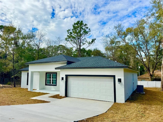 view of front of property featuring central AC unit and a garage