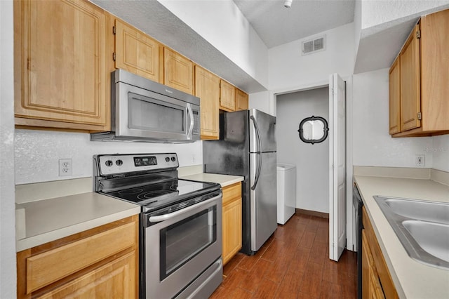 kitchen with stainless steel appliances, sink, light brown cabinetry, and dark hardwood / wood-style floors