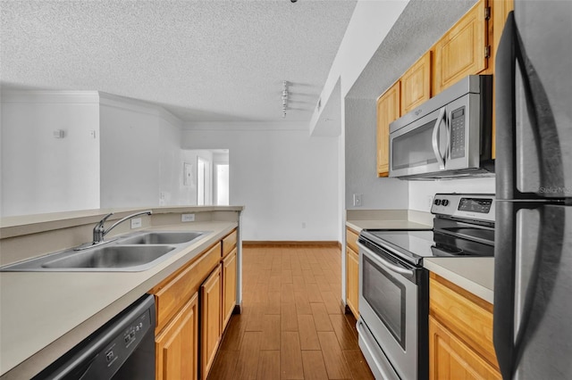 kitchen featuring light brown cabinetry, sink, a textured ceiling, light hardwood / wood-style floors, and black appliances