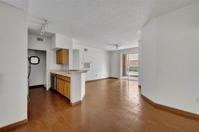 kitchen with track lighting, black dishwasher, a textured ceiling, and light wood-type flooring