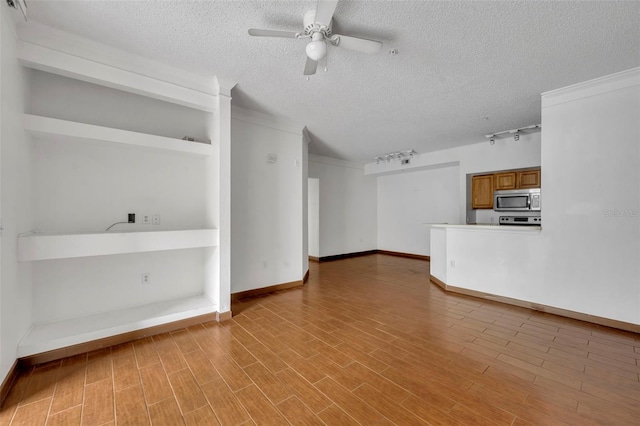 unfurnished living room featuring crown molding, a textured ceiling, light wood-type flooring, track lighting, and ceiling fan